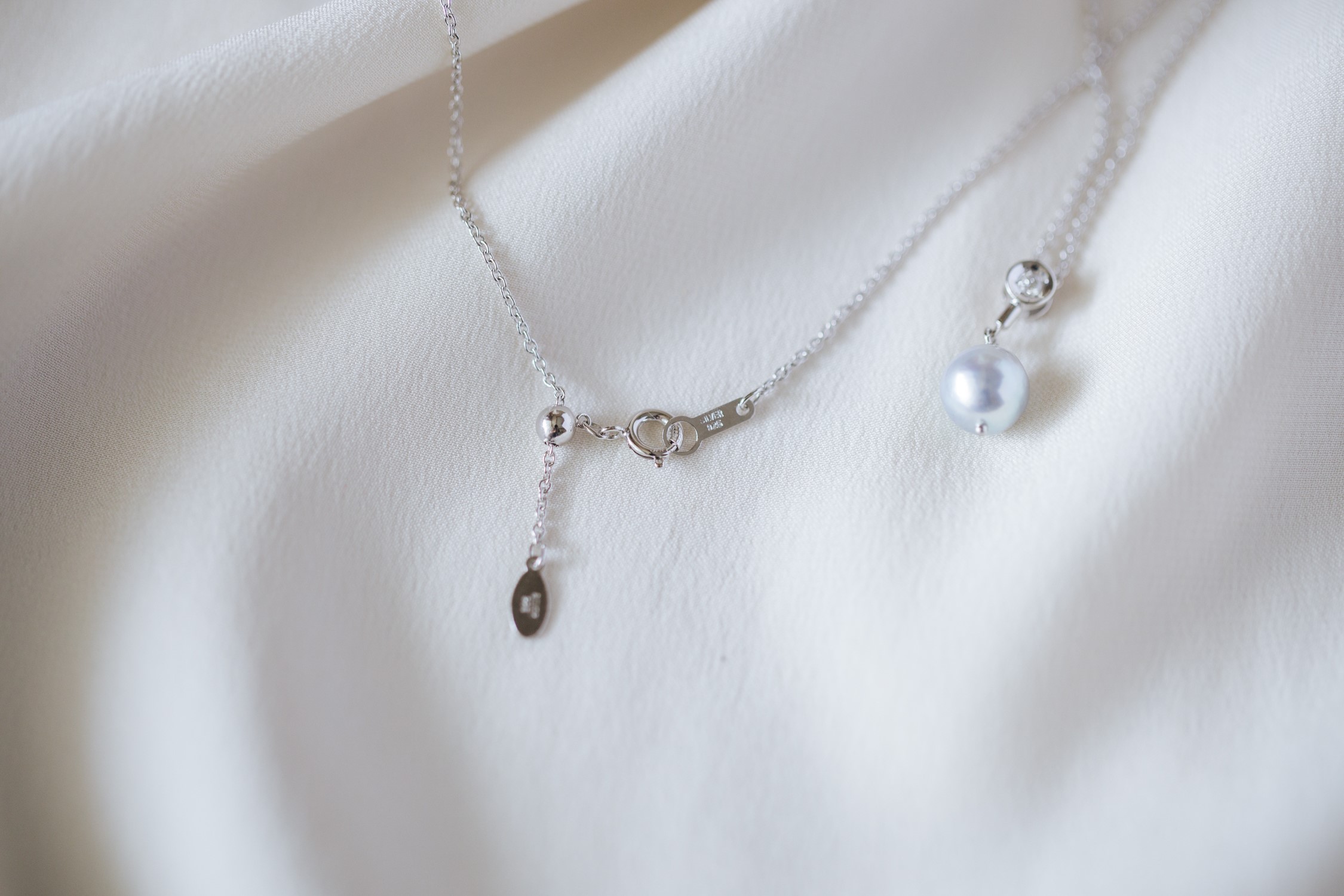 Pearl pendant necklace on white satin
