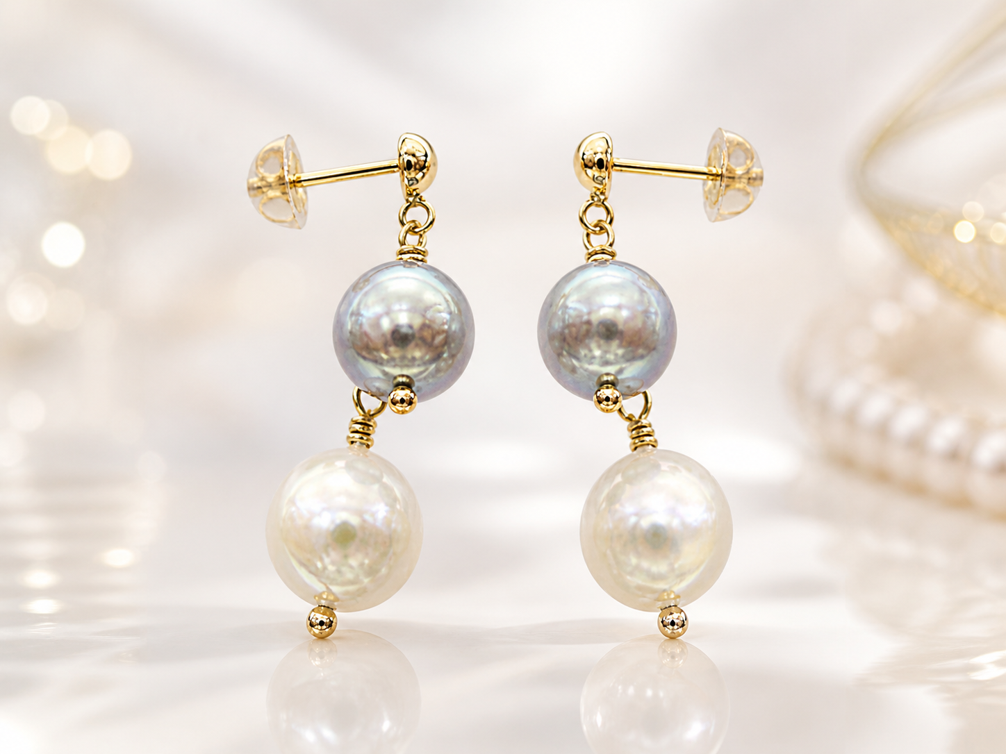 Akoya pearl earrings with gold details on a luminous background